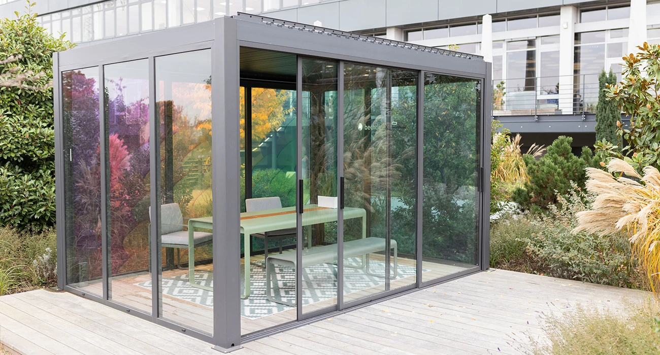 This is an image of a modern, outdoor glass gazebo with geometric design.
